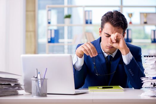 Tired businessman exhausted after hard work and excessive workload