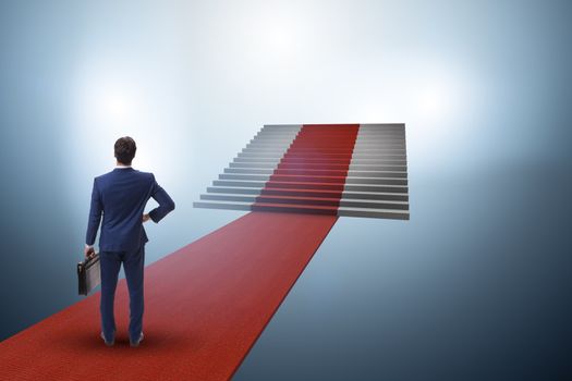 Young businessman climbing stairs and red carpet