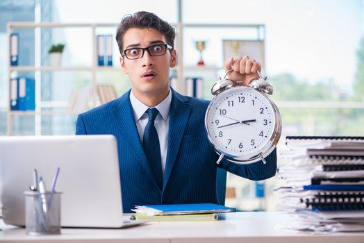Businessman with giant clock failing to meet deadlines and missing them