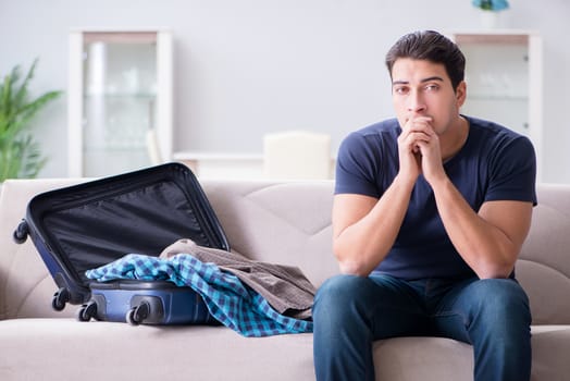 Young man preparing packing for summer vacation