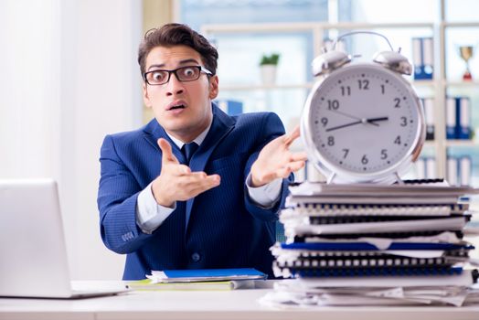 Businessman with giant clock failing to meet deadlines and missing them