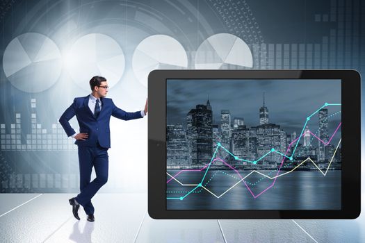Businessman standing next to tablet computer in business concept