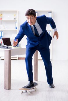 Young businessman with skate in office in sports concept
