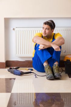 Young repairman contractor repairing heating panel 