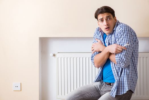 Young repairman contractor repairing heating panel 