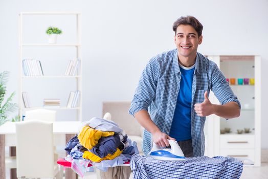 Young man husband doing clothing ironing at home