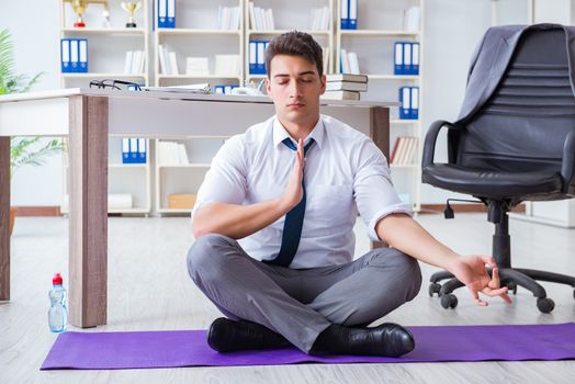 Man meditating in the office to cope with stress