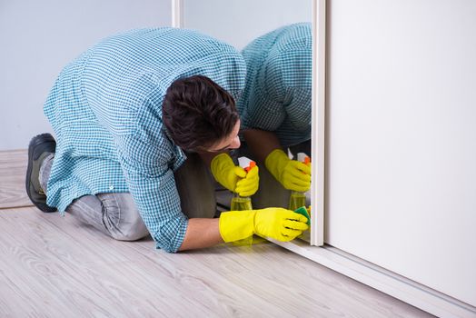 Young man cleaning mirror at home hotel