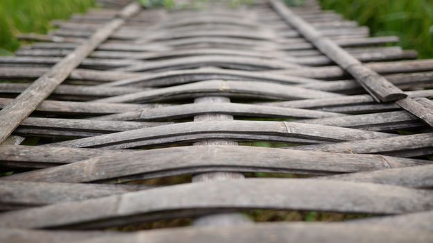Background image of a bridge made of bamboo weaving together. It is a popular bridge made in the countryside in Southeast Asia.