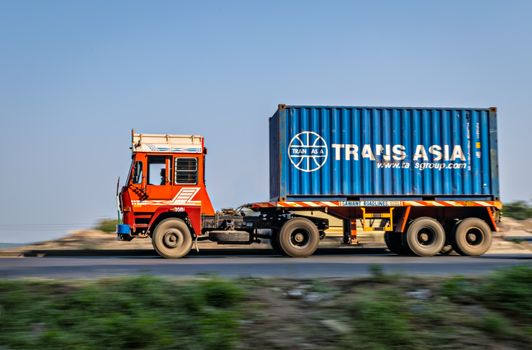 Pune, Maharashtra, India - November 9th, 2017 : Trans-Asia container on trailer , speeding towards Mumbai on highway.