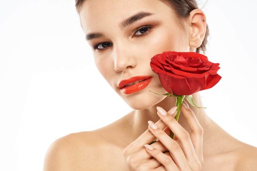 charming brunette girl with makeup on her face and a red rose in her hand. High quality photo