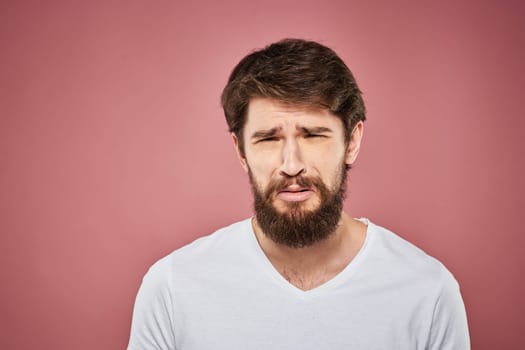 Man in white t-shirt emotions lifestyle facial expression cropped view pink background. High quality photo