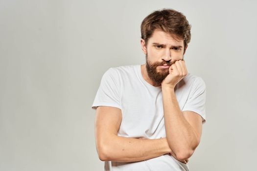 man in white t-shirt gesturing with his hands studio dissatisfaction lifestyle light background. High quality photo