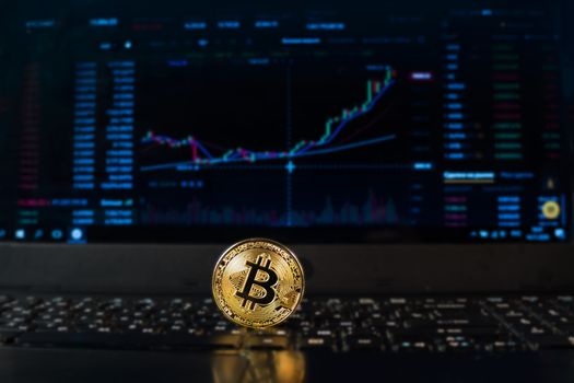 A bitcoin coin on the background of a chart displaying the price on a currency exchange or Forex. Bitcoin exchange rate, electronic money or currency.