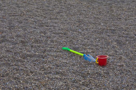 bucket and shovel of children thrown in the stone sand of a park