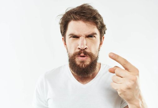 Young man in white t-shirt emotions model gesturing with hands. High quality photo