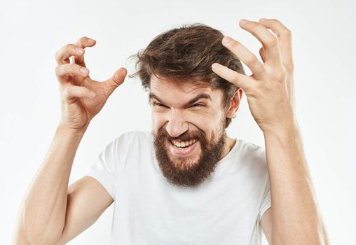 Energetic man in white t-shirt bushy beard gestures with hands cropped view. High quality photo