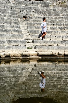 Young girl exploring an ruins of ancient city of Butrint.Olive-shaded archaeological site home to the Greek, Roman & medieval remains of the city of Butrint.