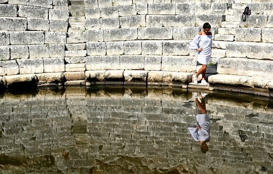 Young girl exploring an ruins of ancient city of Butrint.Olive-shaded archaeological site home to the Greek, Roman & medieval remains of the city of Butrint.