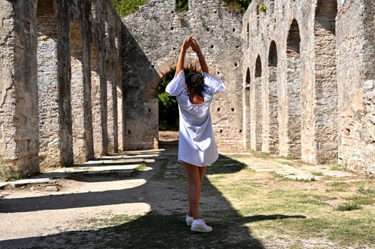 Young girl exploring an ruins of ancient city of Butrint.Olive-shaded archaeological site home to the Greek, Roman & medieval remains of the city of Butrint.