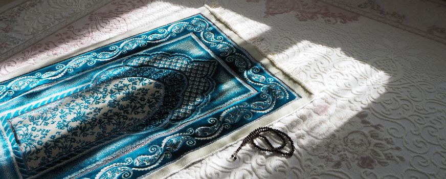 Prayer rug for praying in Islam, prayer rug and rosary laid under daylight,