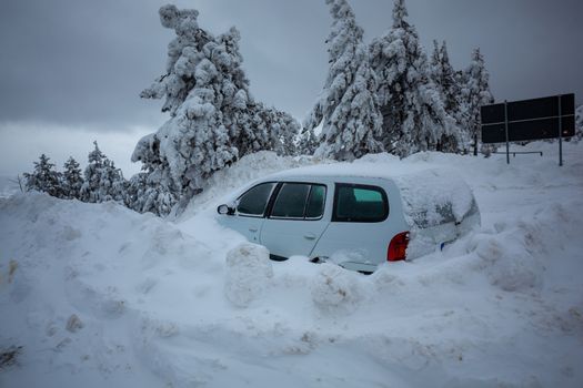 Car stuck in deep snow on mountain road - winter traffic problem stock image