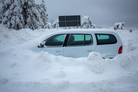 Car stuck in deep snow on mountain road - winter traffic problem stock image