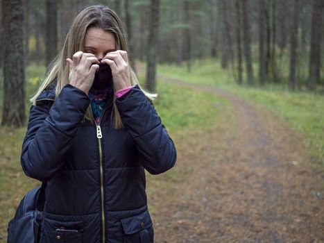 Beautiful european Women Wearing Protective Mask Outside Pretty young girl in medical black face mask in a forest. covid19 concept. modern reality. copy space. 2020, allergy. Autumn season. Copy space