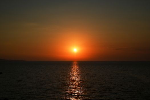 Red sunset over the sea, rich in dark clouds, rays of light, captured near Saranda, Albania