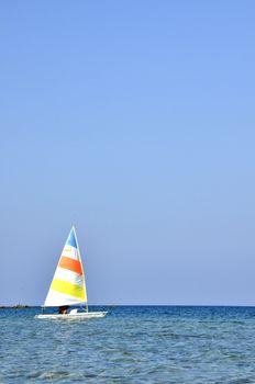 A colorful sailboat with a captain sails the Cyprus Sea during summer vacation