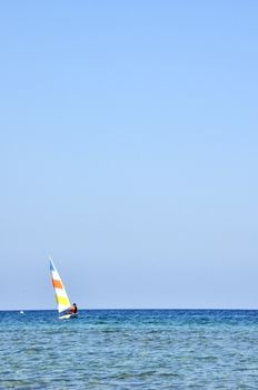 A colorful sailboat with a captain sails the Cyprus Sea during summer vacation