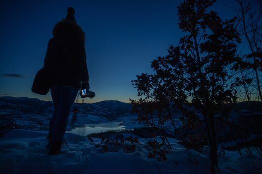 Photographers photographing winter lake mountain scene in sunset, alone in wilderness. Rovni, Valjevo, Serbia