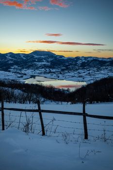 Colorful sunset evening at mountain lake Rovni in snow, beautiful nature winter scene in Serbia