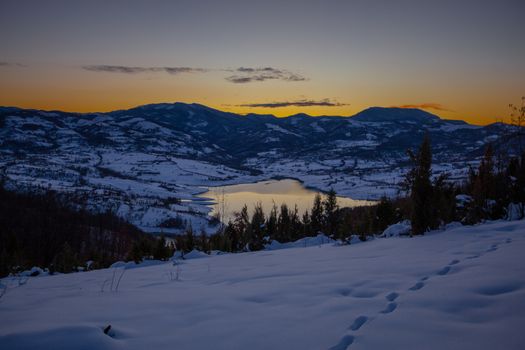 Colorful sunset evening at mountain lake Rovni in snow, beautiful nature winter scene in Serbia