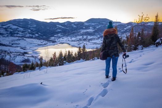 Photographers photographing winter lake mountain scene in sunset, alone in wilderness. Rovni, Valjevo, Serbia