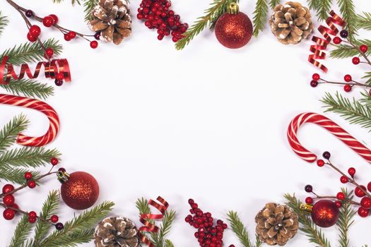 Winter and Christmas frame composition with blank white background, fir tree branch holly berries and pine cones isolated with copy space