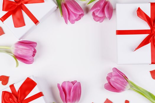Pink tulip flowers gifts red hearts and gifts composition on white background top view with copy space. Valentine's day, birthday, wedding, Mother's day concept. Copy space