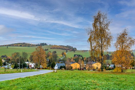 autumn rural panorama with a view of the village, trees and fields.