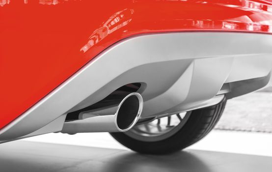 Exhaust pipe of a red car. Ecology concept, low emission, low environmental impact.