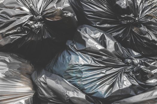 Garbage pile black plastic bags and trash bag waste pollution. Stack of black garbage bags.Black plastic bags for packaging waste.