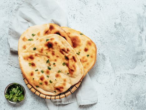 Fresh naan bread on gray cement background with copy space. Top view of several perfect naan flatbreads