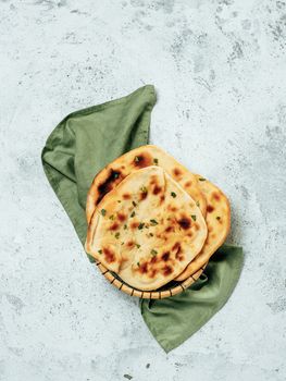 Fresh naan bread on gray cement background with copy space. Top view of several perfect naan flatbreads. Vertical