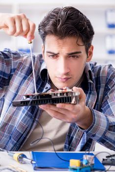 Professional repairman repairing computer in workshop