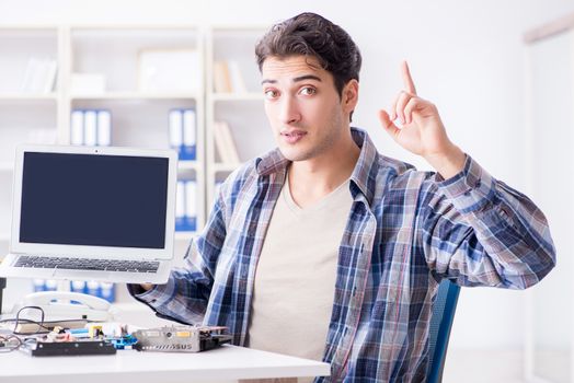 Professional repairman repairing computer in workshop