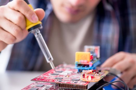 Professional repairman repairing computer in workshop