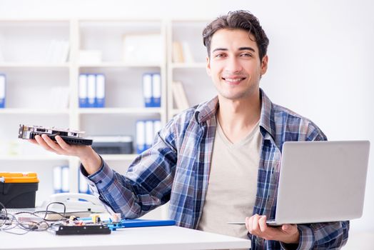 Professional repairman repairing computer in workshop
