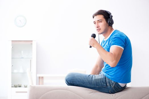 Young man singing at home karaoke