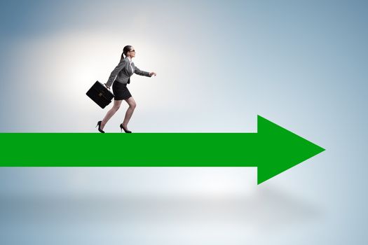 Businesswoman walking on arrow sign