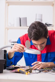 Professional repairman repairing computer in workshop