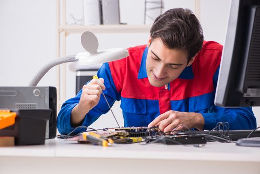 Professional repairman repairing computer in workshop